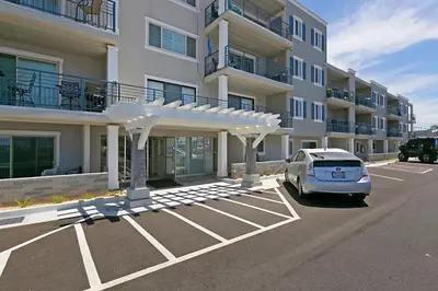 a car parked in a parking lot in front of a building at 215A - Beautiful Sunsets, Beach View, Free Wifi in Oceanside
