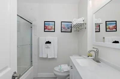 a white bathroom with a sink and a toilet at 303B Perfect Location Beach Across the Street - Walk to Shops Dining - Harbor Views in Oceanside