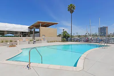 a large swimming pool in front of a building at 307B Steps from the sand! Freshly Decorated with Harbor Views in Oceanside