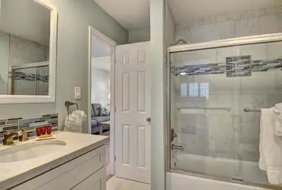 a bathroom with a glass shower and a sink at 307B Steps from the sand! Freshly Decorated with Harbor Views in Oceanside