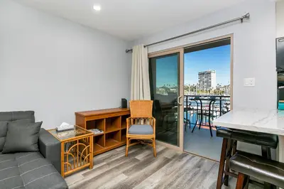 a living room with a couch and a balcony at 308B - Beautiful Harbor Ocean Retreat in Oceanside