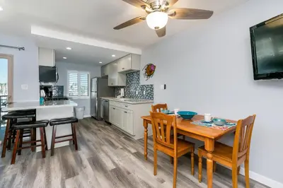 a kitchen and dining room with a table and chairs at 308B - Beautiful Harbor Ocean Retreat in Oceanside