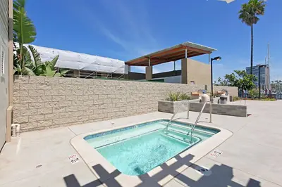 a swimming pool in front of a building at 311B Harbor Views and Steps to the Sand in Oceanside