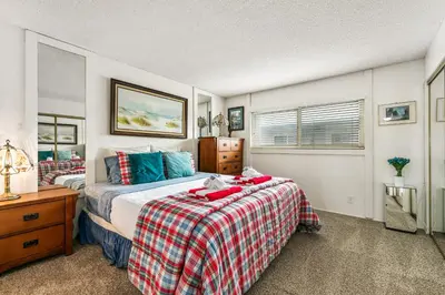 a bedroom with a bed with a plaid blanket at 313B Steps from the Sand at Harbor Beach - Free Wifi in Oceanside