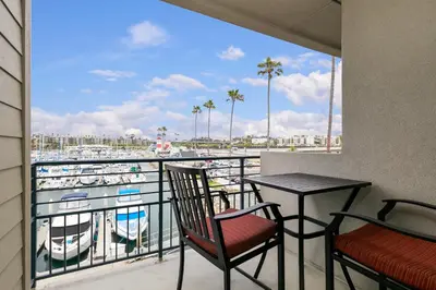 a balcony with a table and chairs and a view of a marina at 313B Steps from the Sand at Harbor Beach - Free Wifi in Oceanside