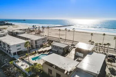 an aerial view of a beach with palm trees and buildings at 313B Steps from the Sand at Harbor Beach - Free Wifi in Oceanside