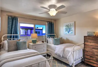 a bedroom with two beds and a ceiling fan at 401B Marina Del Mar Penthouse Harbor & Ocean View in Oceanside