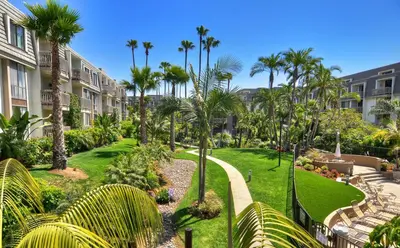 a view of a park with palm trees and buildings at Tropical Water View at North Coast Village C200 in Oceanside