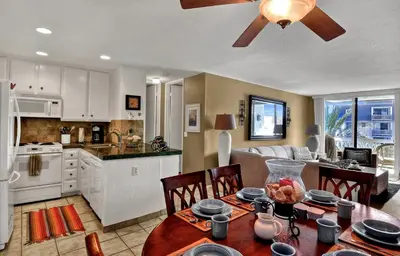 a kitchen and living room with a table and chairs at Tropical Water View at North Coast Village C200 in Oceanside