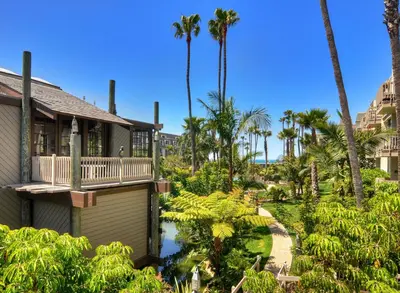 a house with a balcony and palm trees at Tropical Water View at North Coast Village C200 in Oceanside