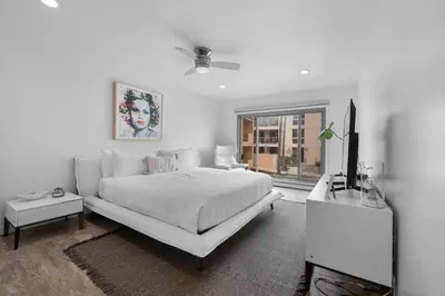 a white bedroom with a white bed and a tv at Beachfront Oasis - 30-Night Minimum in San Diego