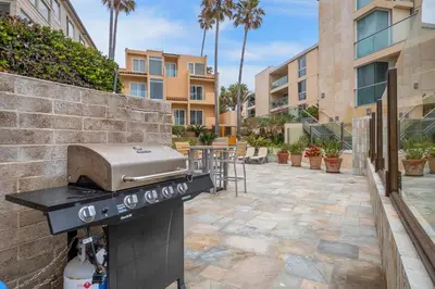 a grill in a courtyard with a building at Beachfront Oasis - 30-Night Minimum in San Diego