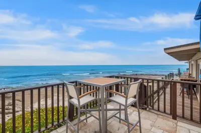 a table and two chairs on a balcony overlooking the ocean at Beachfront Oasis - 30-Night Minimum in San Diego