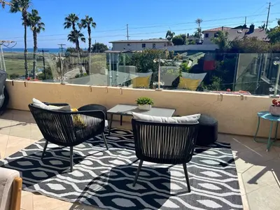 a patio with two chairs and a table on a balcony at Water and sunset views in dreamy Cardiff by the sea in Encinitas