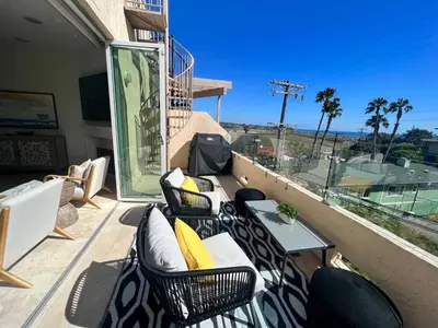 a patio with chairs and a table on a balcony at Water and sunset views in dreamy Cardiff by the sea in Encinitas
