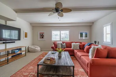 a living room with a red couch and a tv at Water and sunset views in dreamy Cardiff by the sea in Encinitas