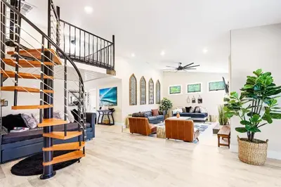 a living room with a spiral staircase in a house at Poppy Cottage in Carlsbad