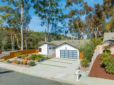 a house with a driveway and a garage at Poppy Cottage in Carlsbad