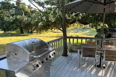 a grill and table on a deck with an umbrella at Julian Orchard Ranch in Santa Ysabel