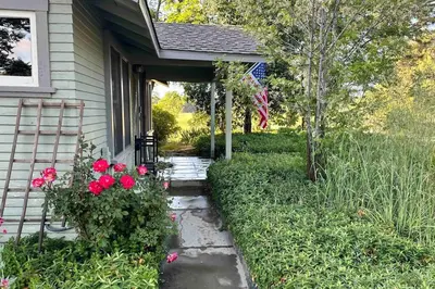 a house with a pathway leading into a yard with red roses at Julian Orchard Ranch in Santa Ysabel