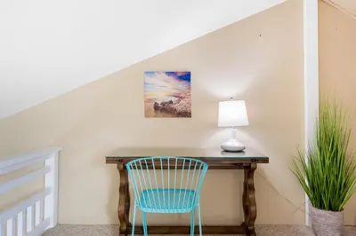 a desk in a room with a blue chair and a lamp at Juniper Coastal Home - 30-Night Minimum in Carlsbad