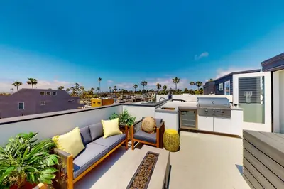 a balcony with a couch and a kitchen on it at Seaside Serenity Retreat in Oceanside