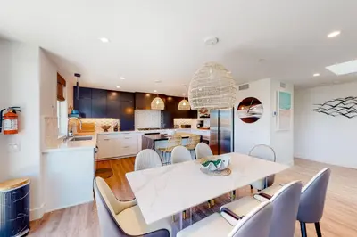 a kitchen and dining room with a white table and chairs at Seaside Serenity Retreat in Oceanside
