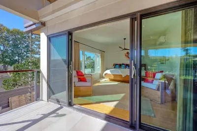 a bedroom with a bed and a balcony with sliding glass doors at Bali Hai, Luxury, High-End Encinitas Home, Large Outdoor Living Area in Encinitas
