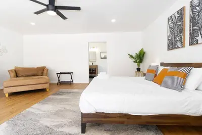 a white bedroom with a large bed and a chair at Modern Luxury in Bonita - 2655sqft with Infinity Pool in Bonita
