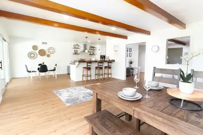 a kitchen and living room with a wooden table at Modern Luxury in Bonita - 2655sqft with Infinity Pool in Bonita
