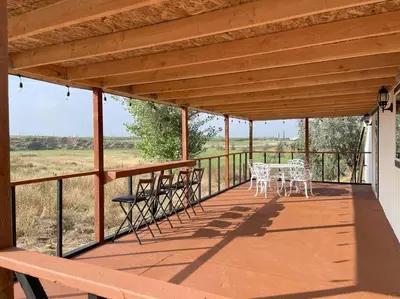 a porch with a table and chairs on it at Modern wine country barn house in Temecula