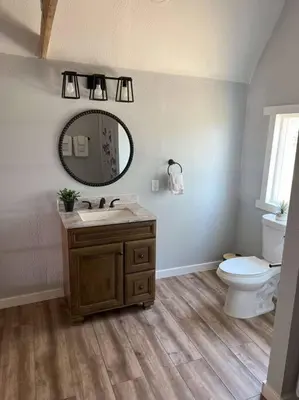 a bathroom with a sink and a toilet and a mirror at Modern wine country barn house in Temecula