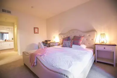 a bedroom with a large white bed with a pink headboard at Irvine Spectrum/2 Bedrooms/2 Bathrooms/Apartment/pool/gym in Irvine