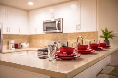 a kitchen with red bowls and plates on a counter at Irvine Spectrum/2 Bedrooms/2 Bathrooms/Apartment/pool/gym in Irvine
