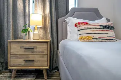 a bed with a pillow and a nightstand with a lamp at Sunlit La Jolla Village Gem with Peak Ocean Views in San Diego