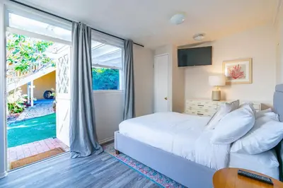 a bedroom with a white bed and a sliding glass door at La Jolla Village's Premier Haven in San Diego