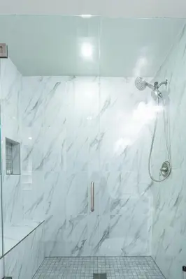 a bathroom with a shower with white marble walls at La Jolla Village's Premier Haven in San Diego