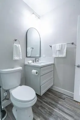 a bathroom with a toilet and a sink and a mirror at La Jolla Village's Premier Haven in San Diego