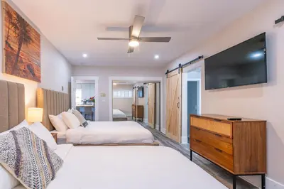 a bedroom with two beds and a flat screen tv at La Jolla Village's Premier Haven in San Diego