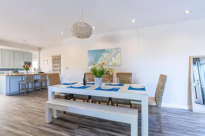 a white dining room with a white table and chairs at La Jolla Village's Premier Haven in San Diego
