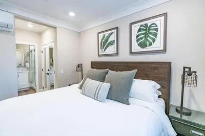 a bedroom with a large white bed with two pictures on the wall at Pristine and Luxe, Steps to Mission Beach and Bay! in San Diego