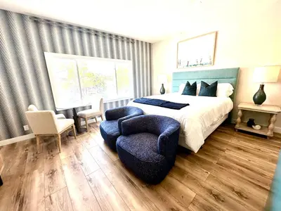 a bedroom with a king sized bed and a chair at AZUL on Avenida Del Mar (1/2 Mile to the PIER!) in San Clemente