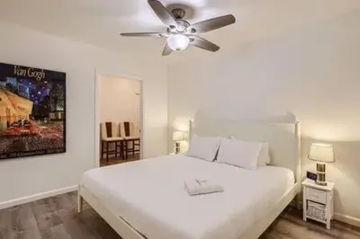 a bedroom with a white bed and a ceiling fan at NEW - 6br home in Oceanside w Games BBQ Outdoor Seating in Oceanside