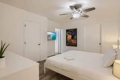 a white bedroom with a bed and a ceiling fan at NEW - 6br home in Oceanside w Games BBQ Outdoor Seating in Oceanside