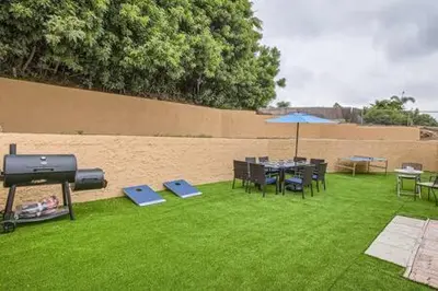 a backyard with a grill and a table and chairs at NEW - 6br home in Oceanside w Games BBQ Outdoor Seating in Oceanside