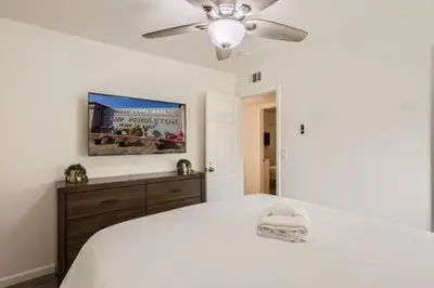 a bedroom with a white bed and a ceiling fan at NEW - 6br home in Oceanside w Games BBQ Outdoor Seating in Oceanside