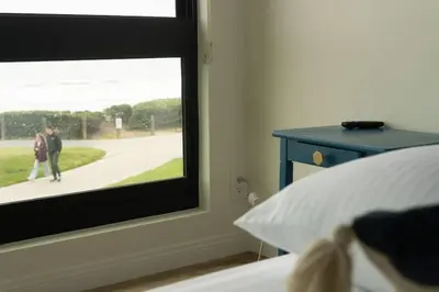 a bedroom with a window with a person walking down a sidewalk at Sunny on the Ocean - Beachfront- Pacific Beach in San Diego