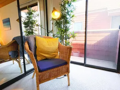 a wicker chair with a yellow pillow in a room at IB Seaside Paradise w/ Ocean Views! in Imperial Beach