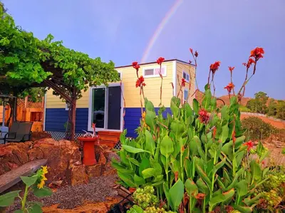 a tiny house with a rainbow in the background at TinyHome at the Sanctuary in Lakeside