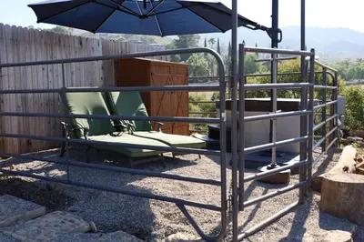 a chair and an umbrella next to a fence at TinyHome at the Sanctuary in Lakeside